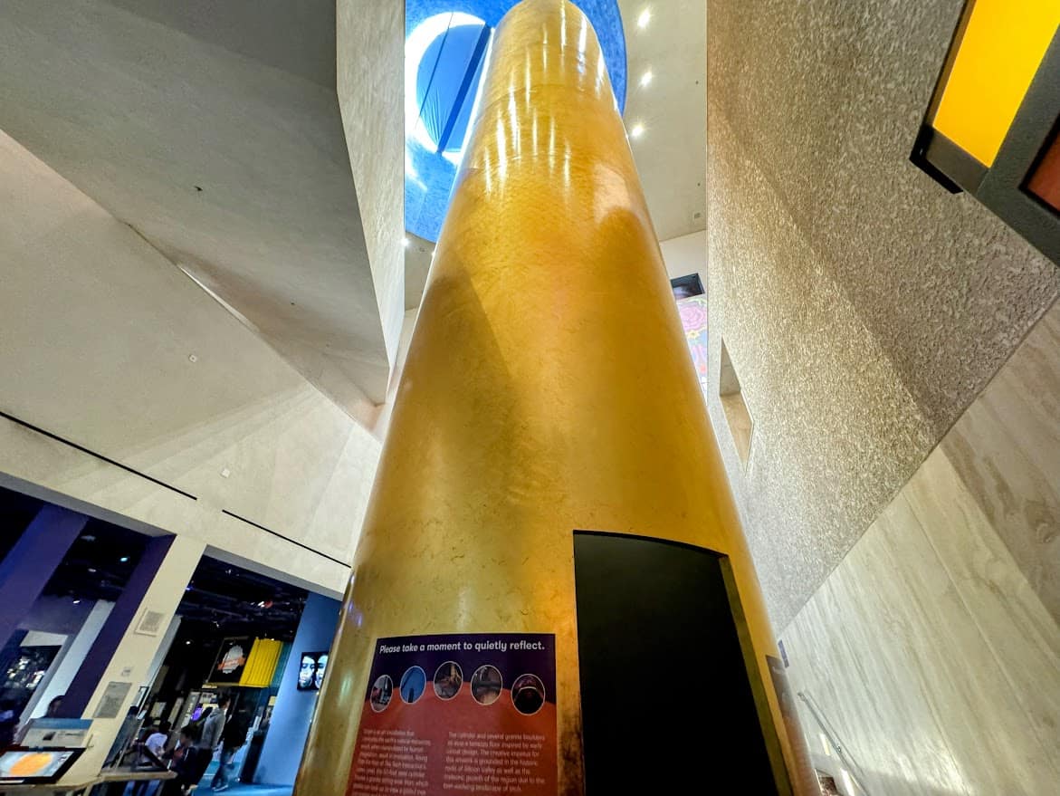 A towering golden-colored installation called the Moment of Reflection, providing a quiet space for visitors to pause and contemplate.