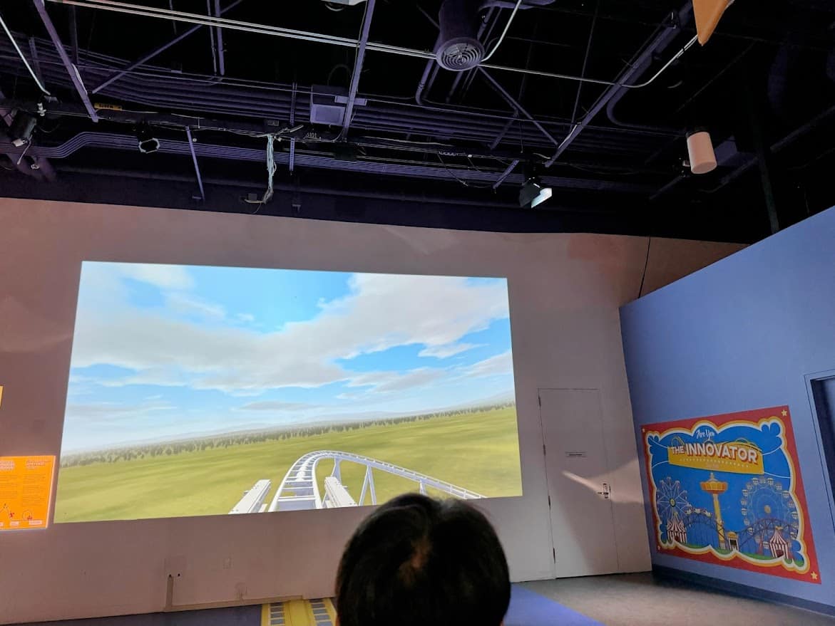 A simulation of a roller coaster projected onto a screen, part of The Innovator exhibit, where visitors can design and experience their own roller coaster.