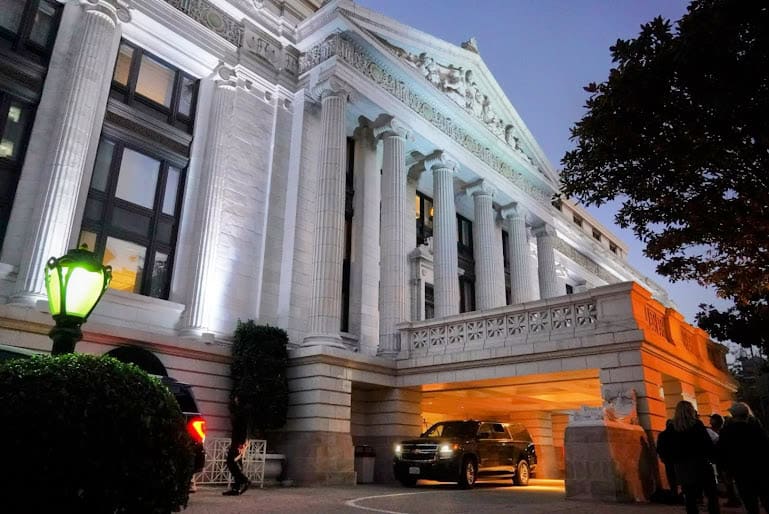 The grand facade of the Ritz-Carlton San Francisco, illuminated at dusk with its iconic white columns and stately architecture exuding timeless elegance.