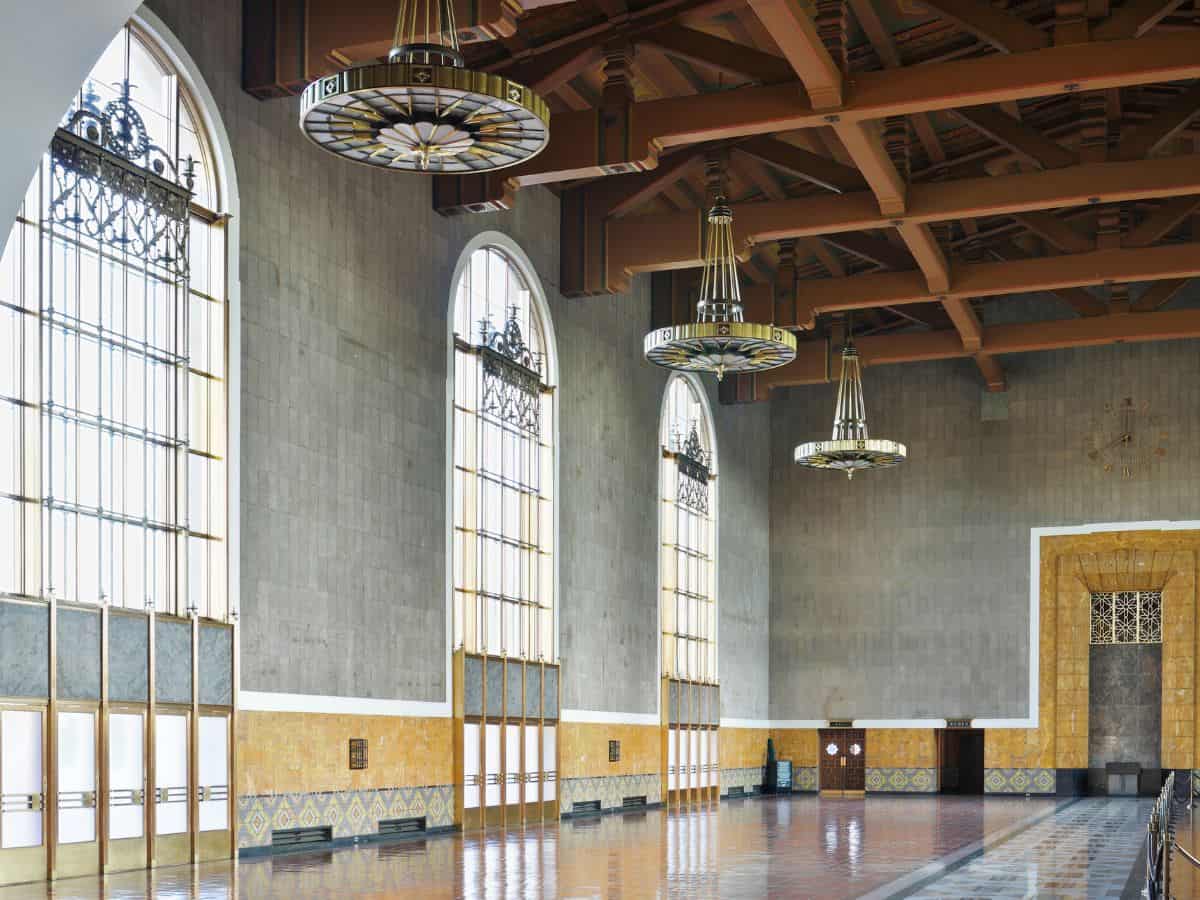 The spacious interior of Union Station with grand arched windows, intricate chandeliers, and decorative tile accents, showcasing its classic Art Deco design.