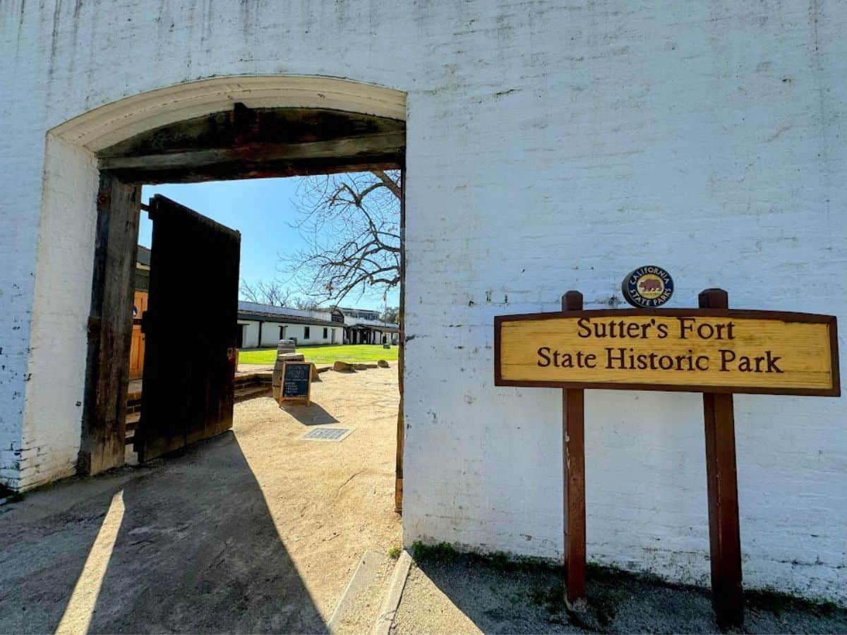 The entrance to Sutter’s Fort State Historic Park, with large wooden doors and a clear sign, offering a step back into California history from the 32 Things To Do In Sacramento list.