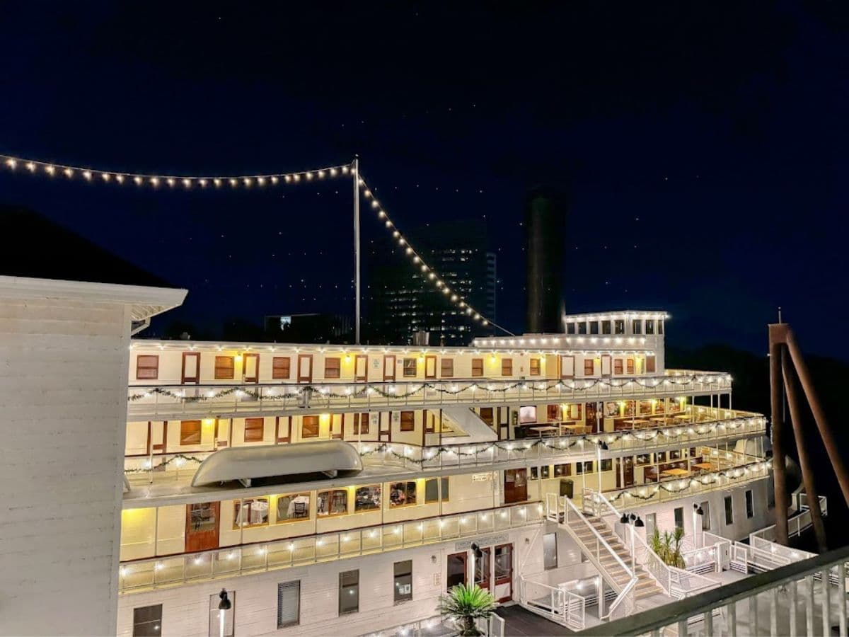 A riverboat decked out in string lights at night, docked along the waterfront, capturing one of the most scenic views in the 32 Things To Do In Sacramento.