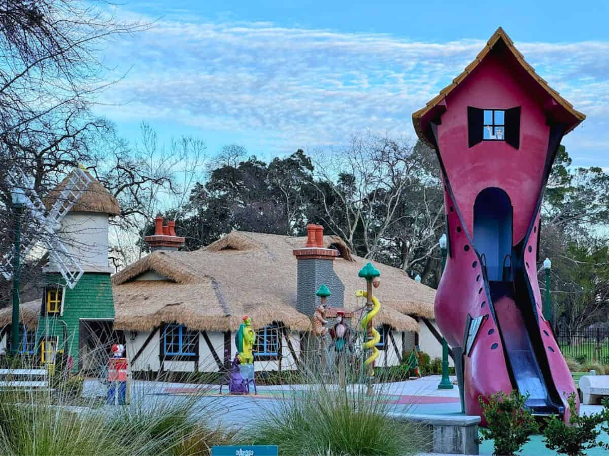 A quirky kids’ play area with colorful storybook-style houses and a tall boot-shaped slide, a playful attraction in the 32 Things To Do In Sacramento guide.