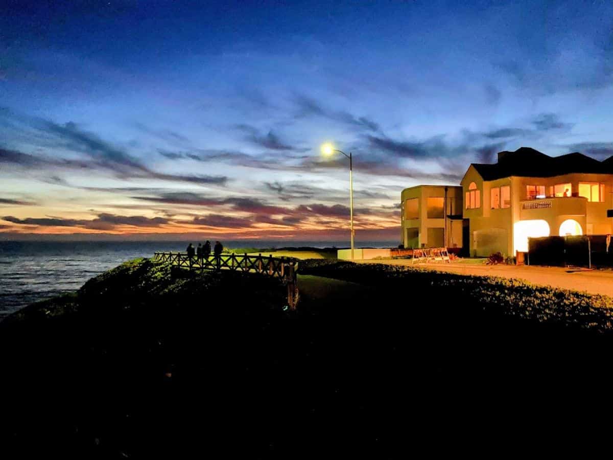 A stunning evening view along West Cliff Drive, where people walk along a scenic coastal pathway. Taking a relaxing stroll or bike ride here is one of the 21 Things to Do in Santa Cruz.