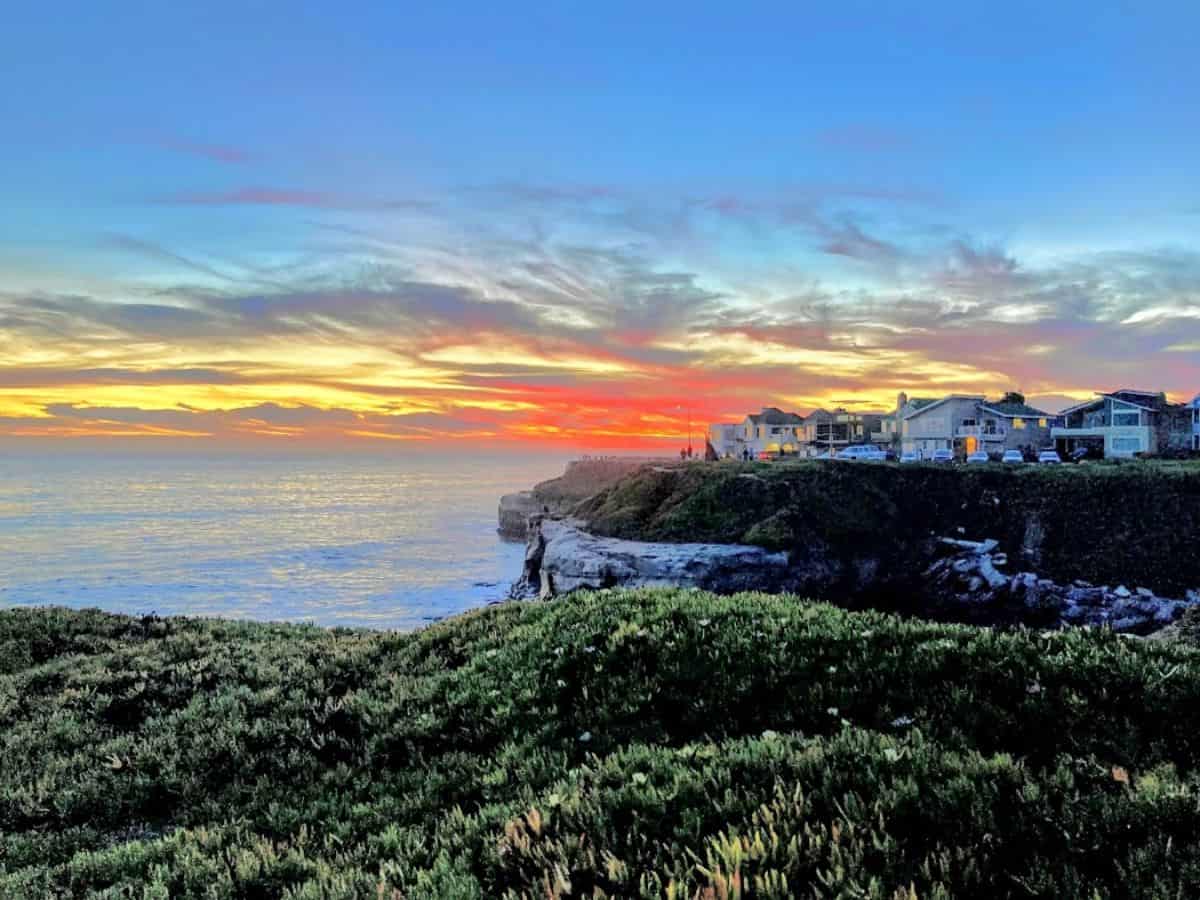 The sky explodes with hues of orange, pink, and blue as the sun sets over the Santa Cruz cliffs. Witnessing a breathtaking sunset along the coast is one of the most magical 21 Things to Do in Santa Cruz.