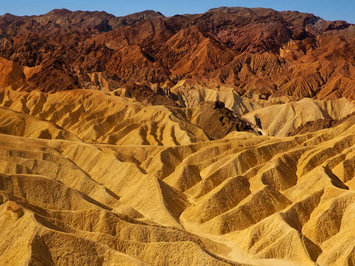 The Mars-like landscape of Death Valley National Park, with its rugged, reddish-brown mountains and golden dunes, resembles Timanfaya National Park in Spain.