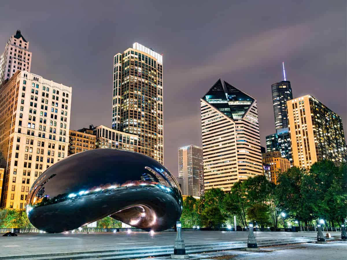 Night view of Cloud Gate in Millennium Park with illuminated city skyscrapers in the background—Millennium Park is easily one of the Top 10 Things to Do in Chicago, Ranked by Popularity.