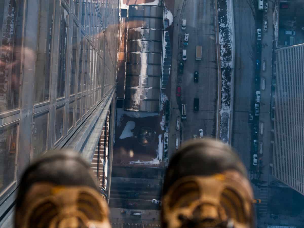 Looking down through the glass floor from the Skydeck of Willis Tower with a bird’s-eye view of the Chicago streets below—an unforgettable thrill among the Top 10 Things to Do in Chicago, Ranked by Popularity.