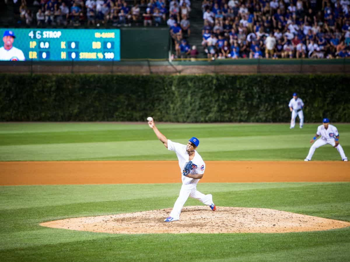 Action shot of a Chicago Cubs pitcher throwing the ball during a game at Wrigley Field with a packed stadium behind—catching a game here is a must on the list of Top 10 Things to Do in Chicago, Ranked by Popularity.