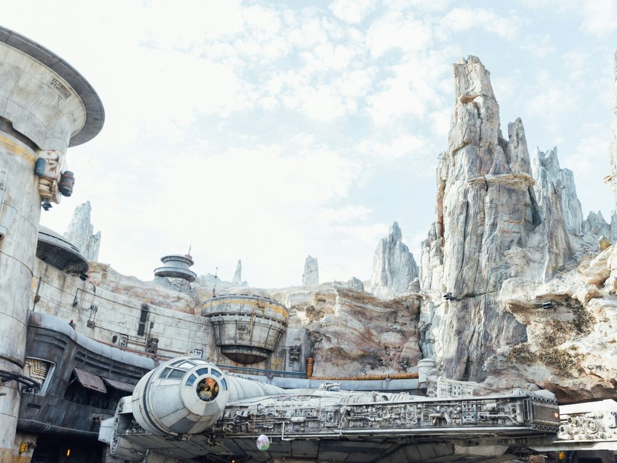 Star Wars: Galaxy’s Edge showcasing the Millennium Falcon parked under jagged rocky spires, creating an immersive intergalactic outpost vibe at Disneyland.