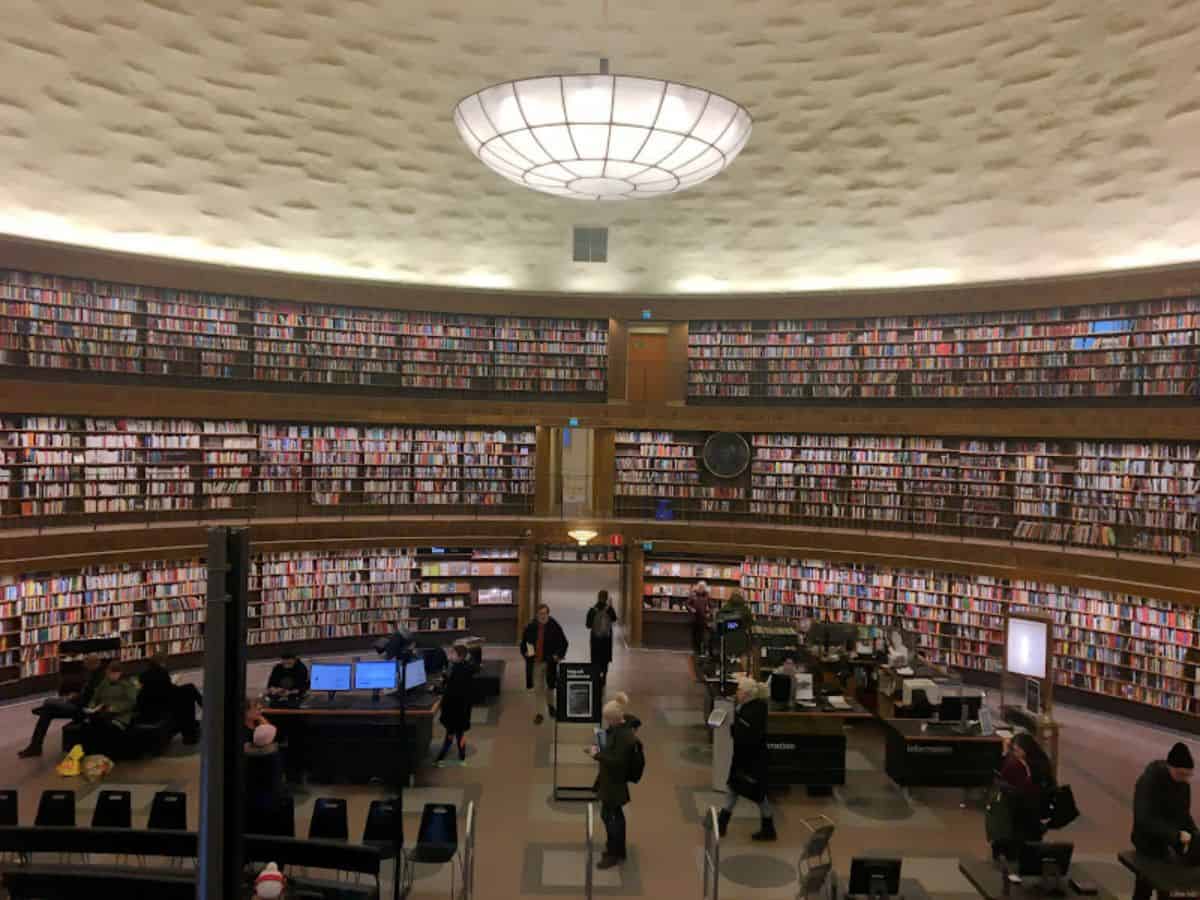 The circular reading room of Stockholm’s Public Library features floor-to-ceiling bookshelves wrapping around a central info desk, beneath a dome-shaped ceiling.