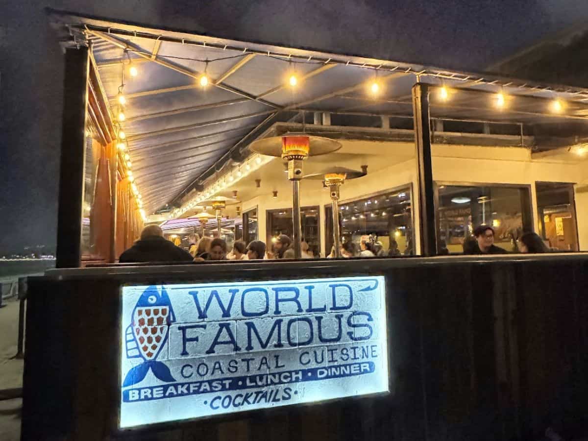 World Famous, a highlight among the best restaurants in Pacific Beach San Diego, seen at night with its name lit up above the entrance, inviting guests in for coastal cuisine and cocktails