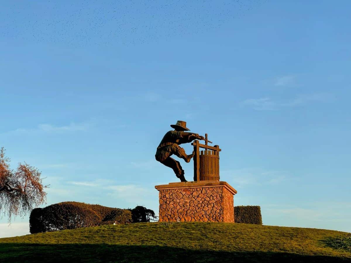 Iconic silhouette of The Grape Crusher statue atop a hill at golden hour, symbolizing Napa’s winemaking heritage and a popular photo spot among the 17 things to do in Napa.