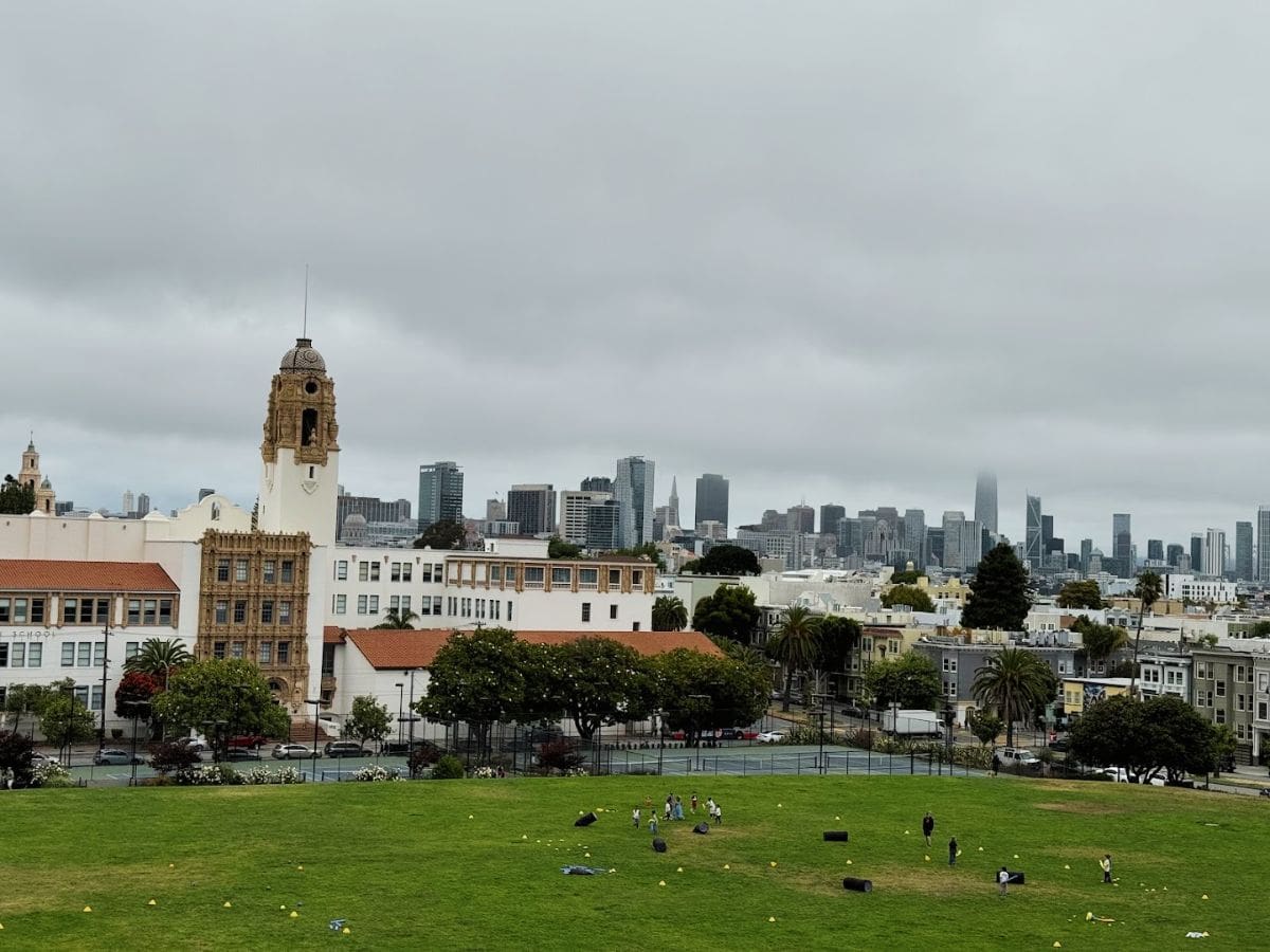 Historic San Francisco skyline with cityscape and greenery on cloudy day.
