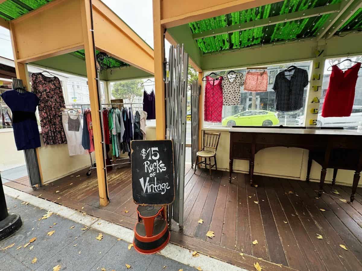 Colorful vintage clothing display at outdoor thrift shop, affordable fashion finds, Bae Area and Beyond.