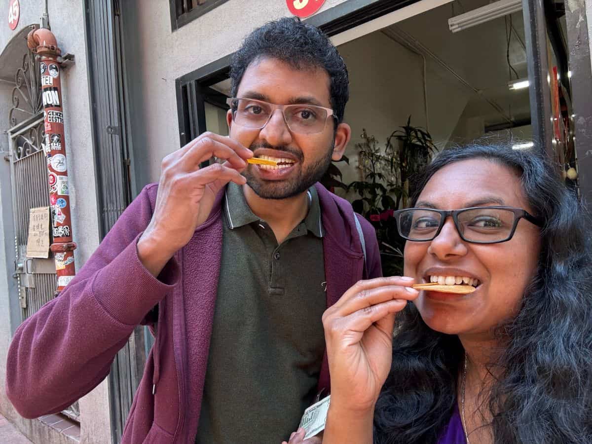 A couple enjoying fortune cookies at one of the Best Spots to eat in San Francisco’s Chinatown.