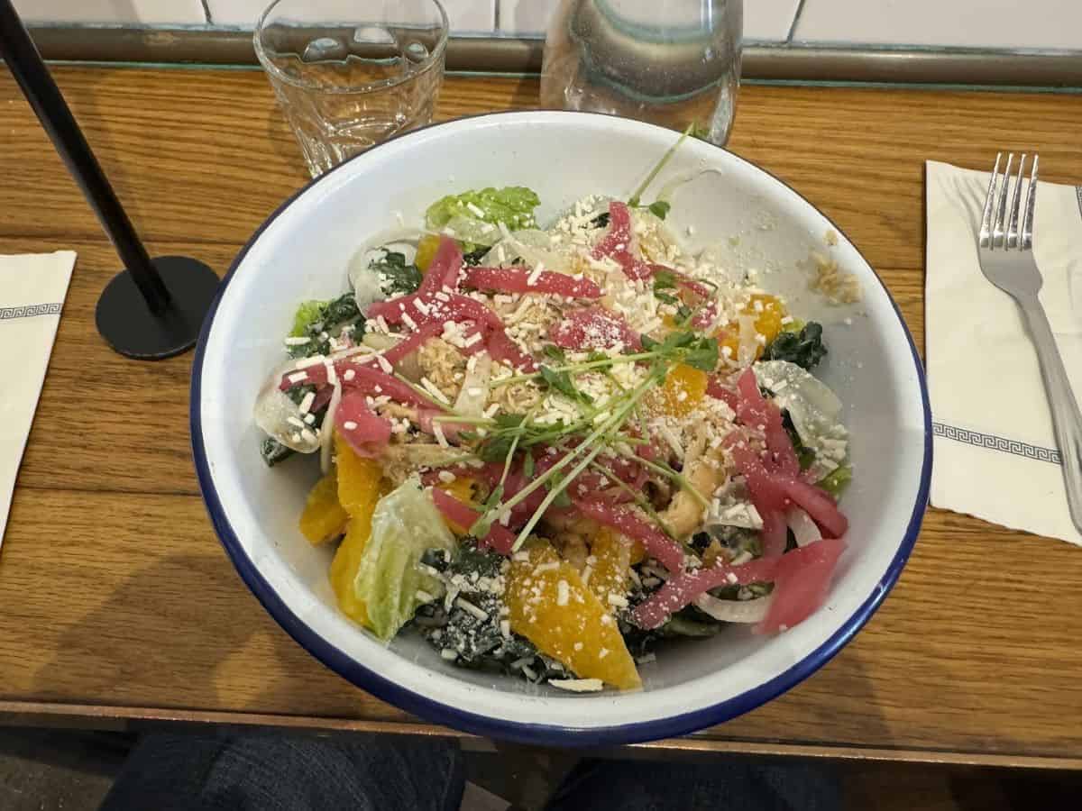 A fresh Greek salad with pickled onions, citrus, and cheese from Souvla, highlighted among the Best Spots to eat in San Francisco.