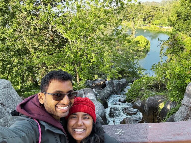 Vibrant couple enjoying a scenic outdoor adventure at Bae Area and Beyond, surrounded by lush greenery and a tranquil river.