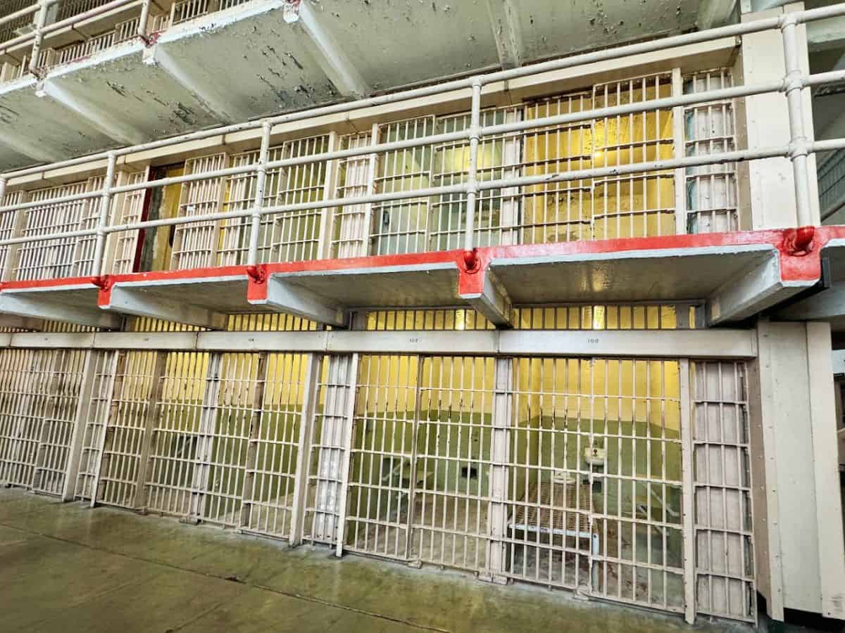 Inside view of Alcatraz prison cells with barred doors and walkways, a historic site near Fisherman’s Wharf